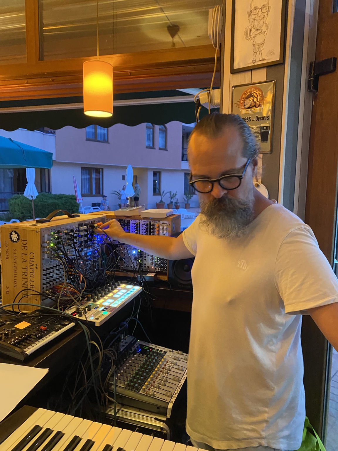 DJ BombOK operating a live electronic rig of synthesisers, modular equipment, drum machines and keyboards